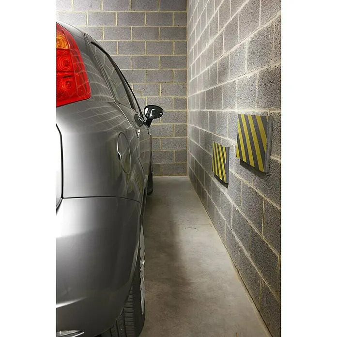 Mottez Anfahrschutz Schaummatte - L x B: 50 x 25 cm, Stärke: 2,5 cm - Nahaufnahme eines Autos, das in einer Garage mit an der Wand befestigten Stoßdämpfern geparkt ist, zum Schutz vor Beschädigungen.