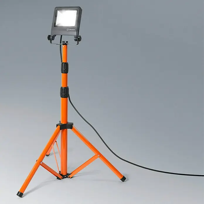 Osram LED-Arbeitsleuchte Tripod L - 2.700 lm, Lichtfarbe: Neutralweiß, IP65, 30 W - Eine tragbare LED-Baustellenleuchte auf einem orangefarbenen Stativ. Die Leuchte strahlt helles Licht aus.