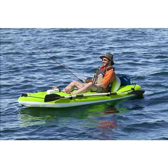 Bestway Hydro Force Kayak Koracle - L x An x Al: 2,7 m x 100 cm x 57 cm, Carga útil: 150 kg, Apto para: 1 persona - Un hombre está sentado en un kayak verde inflable en el agua pescando, con remos a un lado.