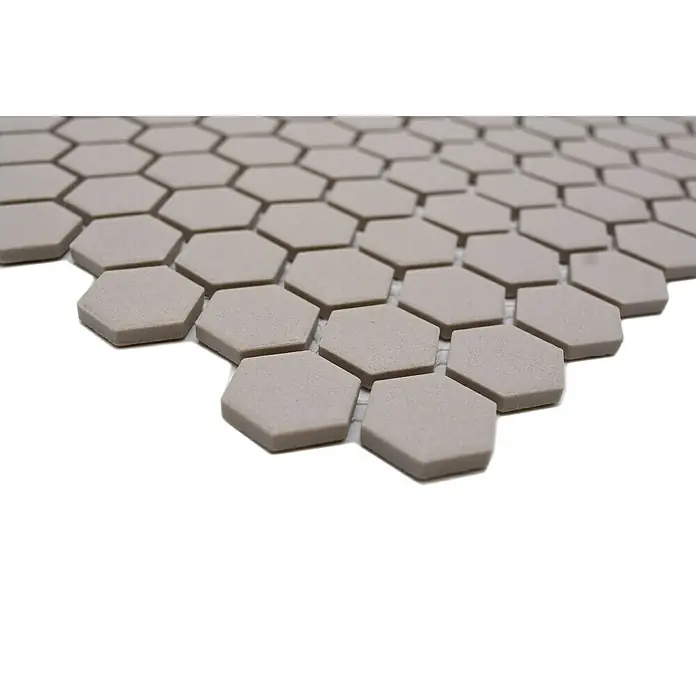 Mosaikfliese Hexagon Uni CU HX017 - 26 x 30 cm, Hellgrau, Matt - Nahaufnahme eines Musters aus sechseckigen, beigen Fliesen, ideal für moderne Wand- und Bodengestaltungen mit einer stilvollen Textur.