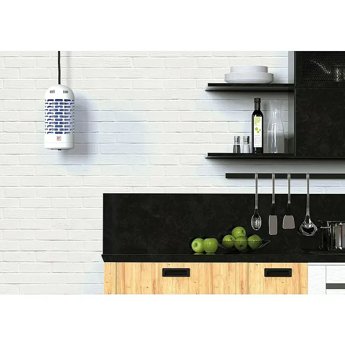 Swissinno Insektenvernichter LED Mini - 3 W, Wirkungsbereich: 20 m² - Bild eines weißen Lufterfrischers, der an einer weißen Ziegelwand in einer modernen Küche hängt. Es verleiht dem Raum ein frisches, sauberes Gefühl.
