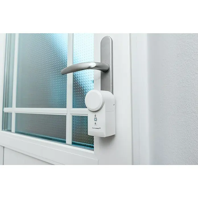 Homematic IP Set Türschlossantrieb mit Keypad & Access Point 2 - L x B x H: 36 x 56 x 118 mm, Weiß - Nahaufnahme eines Homematic IP Türschlossantriebs an einer Tür, der Sicherheit und Komfort bietet.