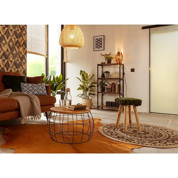 Baufan Pronatur Wandfarbe Lehmfarbe - Naturweiß, Matt, 10 l, Lösemittelfrei - Ein gemütliches Wohnzimmer mit einem braunen Ledersofa, einem runden Couchtisch und einem dekorativen Bücherregal.