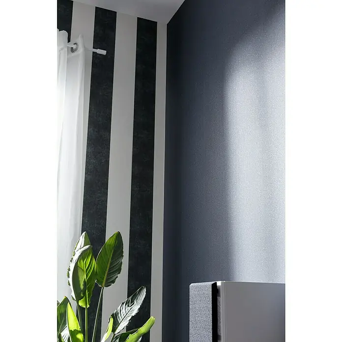 A.S. Création Vliestapete Life 2 - Schwarz/Metallic, Uni, 10,05 x 0,53 m - Nahaufnahme einer modernen Wandgestaltung mit breiten, vertikalen Streifen und einem Hauch von Natur durch eine Zimmerpflanze.