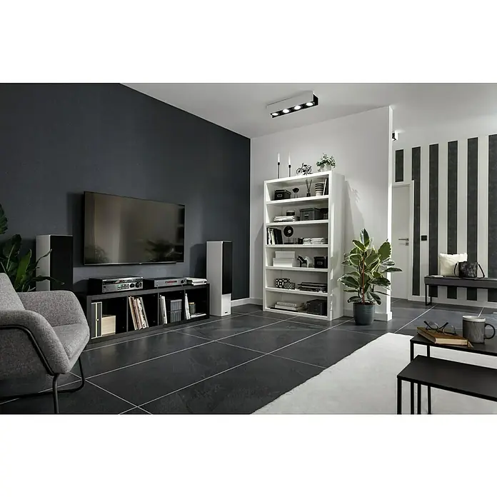 Feinsteinzeugfliese Lavagna Nera - 60 x 120 cm, Schwarz, Matt - Ein stilvolles Wohnzimmer mit einem großen Fernsehgerät, einem Regal und einer gemütlichen Sitzecke. Die Einrichtung ist modern und minimalistisch.
