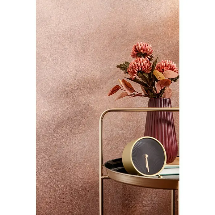 SCHÖNER WOHNEN-Farbe Trendstruktur Farbeffektputz Metall-Optik Effektfarbe - Kupfer, Glänzend, 375 ml - Nahaufnahme eines Tisches mit einer Uhr, einer Vase mit Blumen und einem modernen Design, der eine elegante Dekoration zeigt.