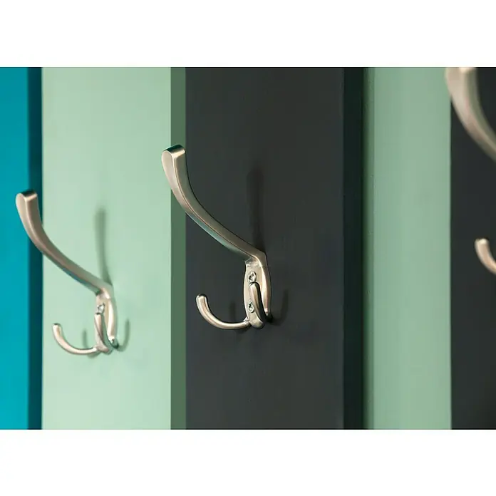 SCHÖNER WOHNEN-Farbe Wandfarbe Trendfarbe - Frozen, Matt, 2,5 l, Konservierungsmittelfrei - Nahaufnahme von Kleiderhaken an einer mehrfarbigen Wandgarderobe, die Funktionalität und modernes Design vereint.