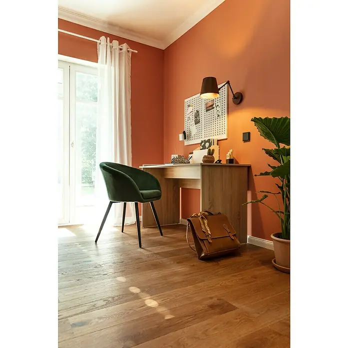 Living by Haro Designbodenmuster Eiche Mokkabraun - 290 x 173 x 12 mm, Landhausdiele - Ein Arbeitszimmer mit einem Holztisch, einem grünen Stuhl, einer Lampe und einer Dekotafel an der Wand. Eine stilvolle Einrichtung für das Homeoffice.