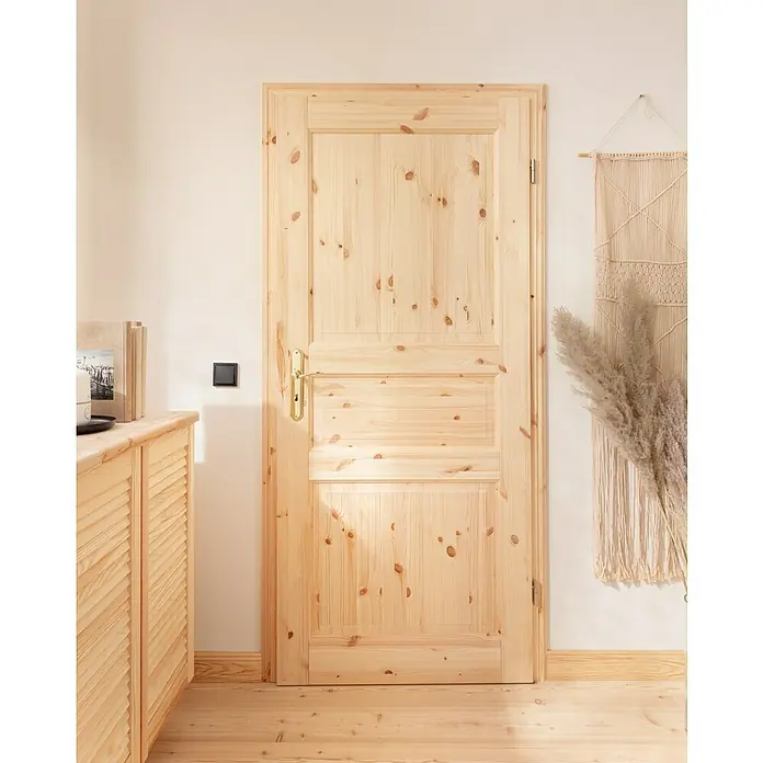 Kilsgaard Landhaustür 02/03 - 735 x 1.985 mm, DIN Anschlag: Rechts, Kiefer natur - Eine helle Holztür mit goldenem Griff fügt sich perfekt in das natürliche Interieur ein und strahlt Wärme und Behaglichkeit aus.