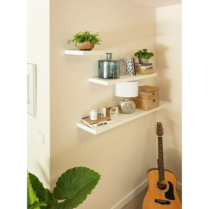 SCHÖNER WOHNEN-Farbe Wandfarbe Designfarbe - Leichtes Leinenbeige, Matt, 1 l - An der Wand montierte, mit Dekorationen versehene weiße Regale, die eine moderne und stilvolle Atmosphäre schaffen.