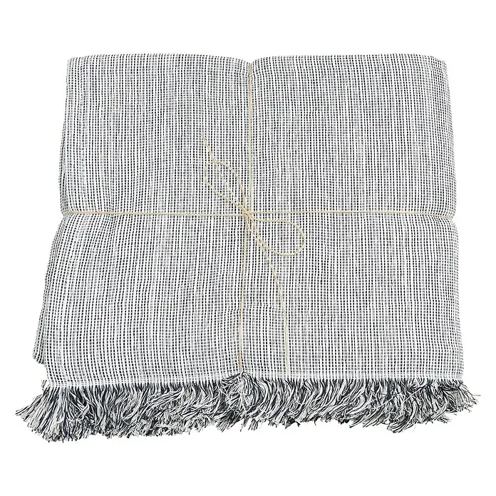 Manta para sofá Multiusos - Marino - Manta de algodón gris y blanco doblada con flecos y cuerda, ideal para las tardes acogedoras.