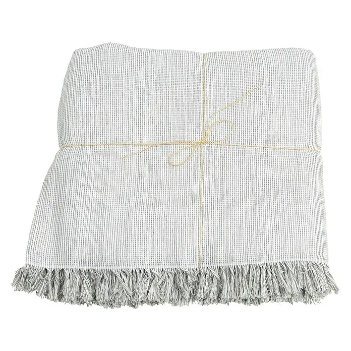 Manta para sofá Multiusos - Gris Plata - Manta gris doblada con flecos y cuerda para un toque decorativo en el hogar.