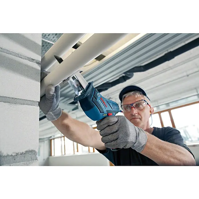 Bosch Professional Akku-Säbelsäge GSA 12V-14 - 12 V, Li-Ionen, 2 Akkus, 3 Ah - Ein Mann benutzt eine Bosch GSA 10,8 V-LI Akku-Säbelsäge, um ein Rohr zu schneiden. Er trägt Handschuhe und eine Schutzbrille.
