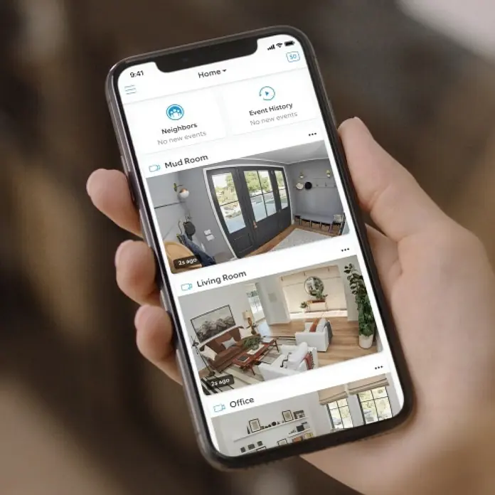 Ring Überwachungskamera außen Stick Up Cam Battery - Akkubetrieben, 1.080 Pixel (Full HD), Weiß - Eine Hand hält ein Smartphone mit der Ring-App, die Überwachungskamera-Ansichten von Mud Room, Living Room und Office zeigt.