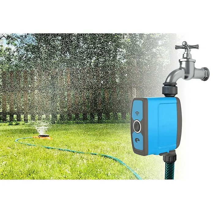 Garza Smart Home Enchufe inteligente y Controlador de riego - Gris, Plástico, IP54, Colocar - Un temporizador de riego inteligente conectado al grifo, con un aspersor regando el césped de fondo.