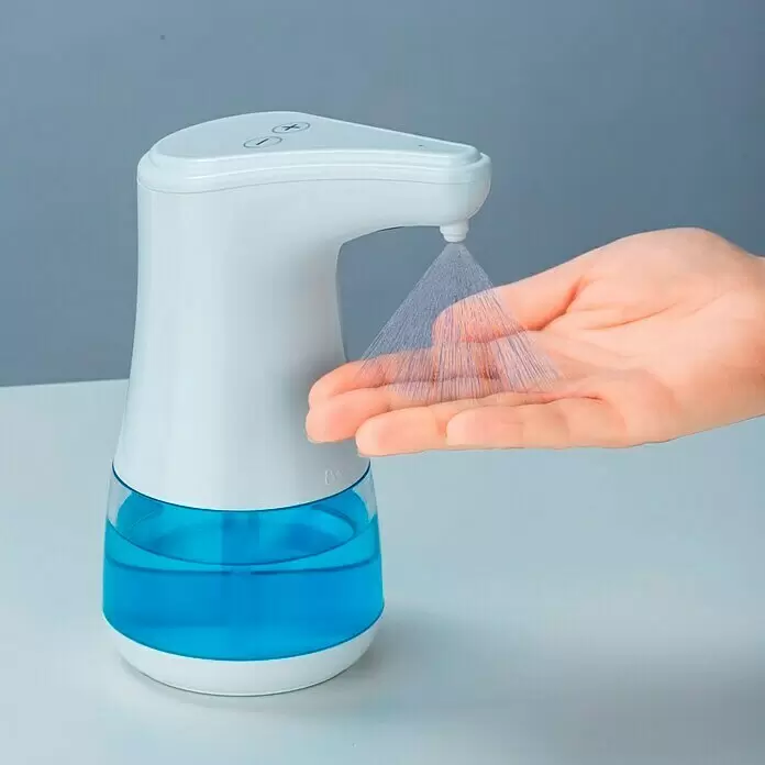 Wenko Desinfektionsmittelspender Diala - Weiß, L x B x H: 19 x 12 x 23 cm - Weiß-blauer automatischer Desinfektionsmittelspender sprüht Flüssigkeit in eine offene Hand.
