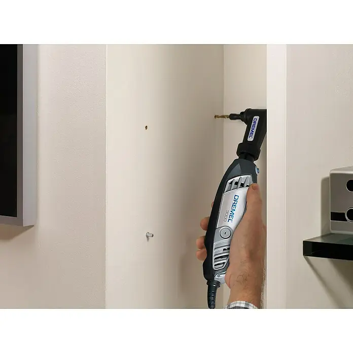 Dremel Winkeladapter 575 - Passend für: Dremel Multifunktionsgeräte - Ein Dremel 3000 Multifunktionswerkzeug mit Winkelvorsatz bohrt ein Loch in eine weiße Wand, um ein Projekt zu unterstützen.