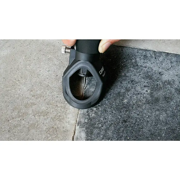 Dremel Fräsvorsatz Mod. 568 - Passend für: Dremel Multifunktionsgeräte, 2 -tlg. - Nahaufnahme eines DRE Pulser-Werkzeugs, das einen Riss in einer Betonoberfläche bearbeitet, gehalten von einer Hand.