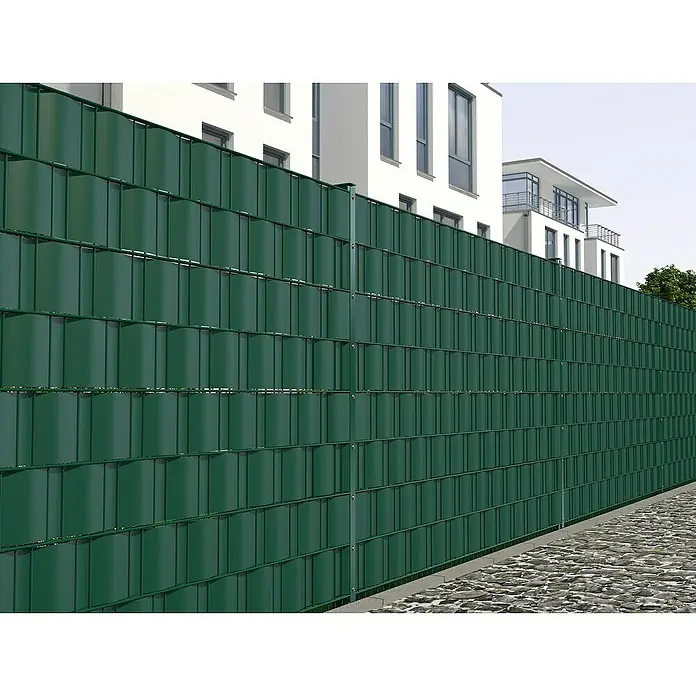 Hadra Sichtschutzstreifen - 250 x 190 cm, Grün - Ein grüner Sichtschutzzaun aus PVC vor einem Wohnhaus. Er bietet Privatsphäre und dient gleichzeitig als dekoratives Element.
