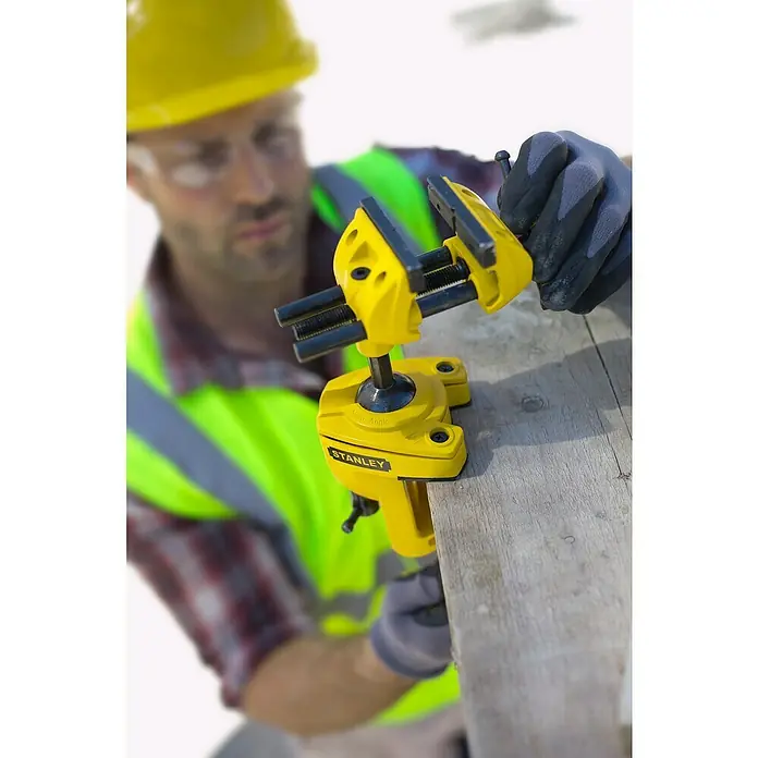 Stanley Schraubstock MaxSteel - Backenbreite: 70 mm - Stanley Multi-Angle-Schraubstock, gut sichtbar in Gelb, an einer Holzplatte befestigt, ideal für präzises Arbeiten in verschiedenen Winkeln.
