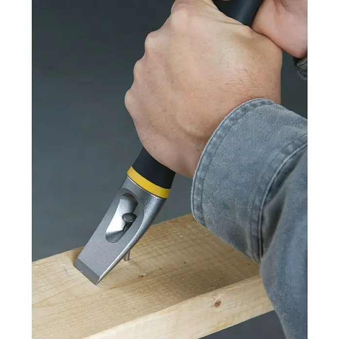 Stanley FatMax Abbruchwerkzeug Fubar II - Länge: 380 mm, Schwarz/Gelb - Ein Handwerker benutzt ein Stemmeisen, um einen Nagel aus einem Holzbrett zu entfernen. Das Stemmeisen hat einen gelben Akzent.