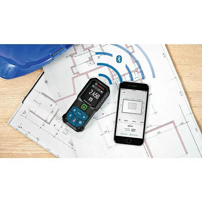 Bosch Professional Laserentfernungsmesser GLM 50-27 CG - Anzahl Akkus: Ohne Akku, Messbereich: 0,05 - 50 m - Das Bild zeigt einen Bosch Entfernungsmesser mit Bluetooth-Funktion neben einem Smartphone und Bauplänen.