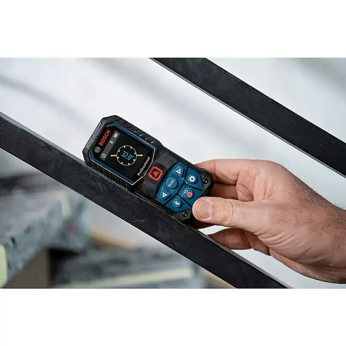 Bosch Professional Laserentfernungsmesser GLM 50-27 C - Messbereich: 0,05 - 50 m - Nahaufnahme eines Bosch-Digital-Winkelmessers, der eine Neigung von 32,0 Grad anzeigt, gehalten von einer Hand vor einem dunklen Geländer.