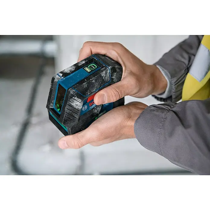 Bosch Professional Linienlaser GLL 2-15 G - Max. Arbeitsbereich: 15 m, 5 -tlg. - Nahaufnahme eines Bosch Professional Laser-Nivelliergeräts in Händen, ideal für präzise Bau- und Renovierungsarbeiten mit grünen Laserlinien.