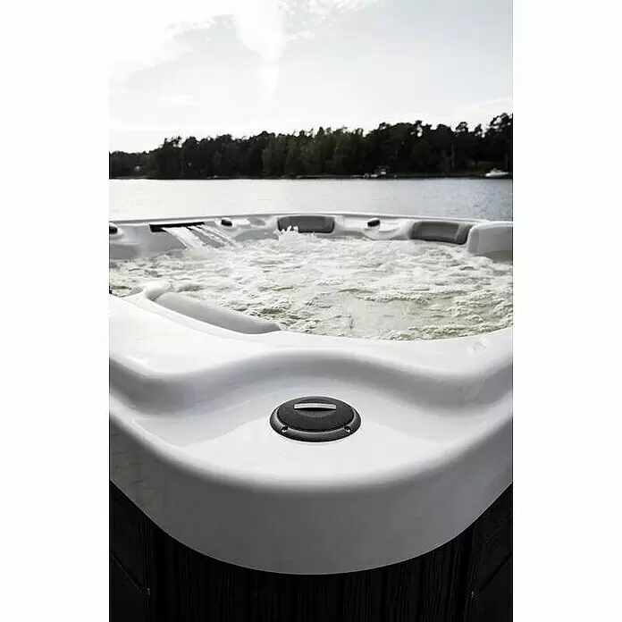 Camargue Außen-Whirlpool Serenity - 213 x 213 x 91 cm, Grau/Weiß, Max. Personenzahl: 6 - Weißer Whirlpool mit sprudelndem Wasser, im Freien an einem See platziert.