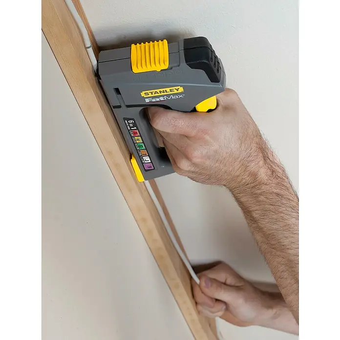 Stanley FatMax Kombi-Handtacker TR75 - Klammertiefe: 14 mm, Geeignet für: Möbelaufarbeitungen - Nahaufnahme eines Stanley FatMax Kabeltackers beim Befestigen eines Kabels an einem Holzrahmen.