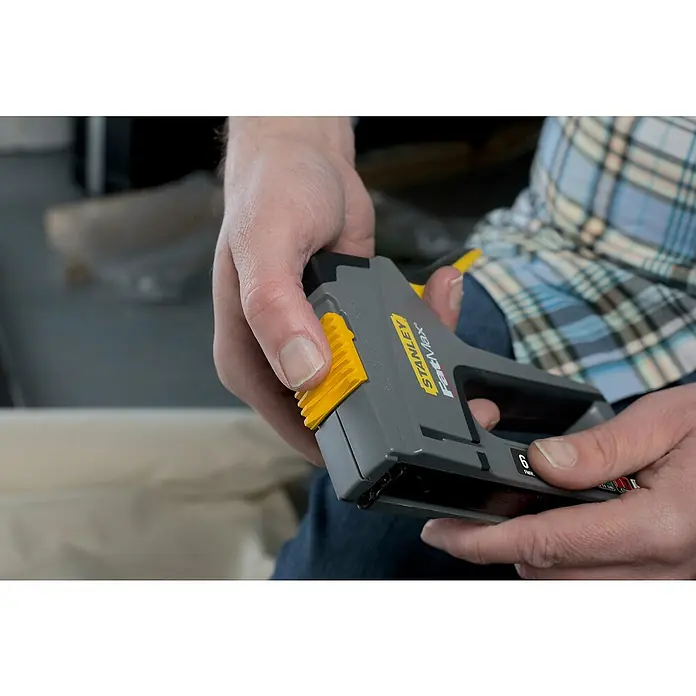 Stanley FatMax Kombi-Handtacker TR75 - Klammertiefe: 14 mm, Geeignet für: Möbelaufarbeitungen - Nahaufnahme einer Person, die einen Stanley FatMax-Tacker hält und bedient, ideal für Heimwerker- und Handwerksprojekte.