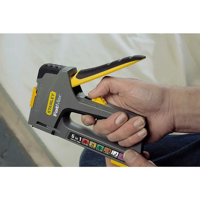 Stanley FatMax Kombi-Handtacker TR75 - Klammertiefe: 14 mm, Geeignet für: Möbelaufarbeitungen - Nahaufnahme eines Stanley FatMax 6-in-1-Tackers, der von einer Hand gehalten wird, mit Fokus auf Design und Funktionalität.