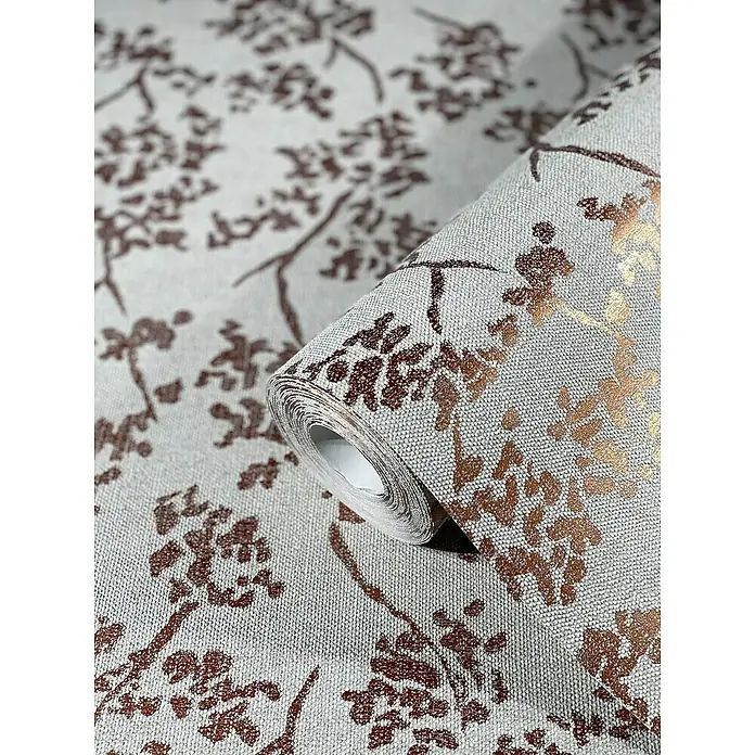 SCHÖNER WOHNEN-Kollektion New Spirit Vliestapete Blüten-Allover - Grau/Gold, Floral, 10,05 x 0,53 m - Nahaufnahme einer Rolle strukturierter Tapete mit floralem Muster in Braun und Metallic-Akzenten auf beigem Grund.