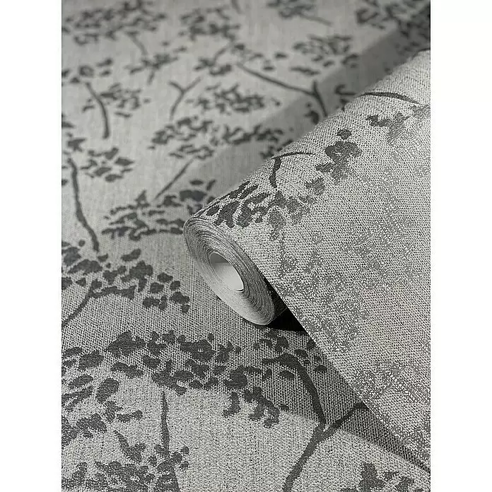 SCHÖNER WOHNEN-Kollektion New Spirit Vliestapete Blüten-Allover - Grau, Floral, 10,05 x 0,53 m - Graue und silberne strukturierte Tapetenrolle mit schimmerndem Astmuster. Teilweise abgerollt.