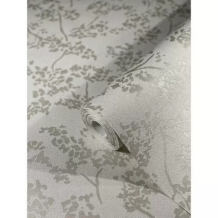 SCHÖNER WOHNEN-Kollektion New Spirit Vliestapete Blüten-Allover - Weiß, Floral, 10,05 x 0,53 m - Rolle hellgraue Struktur-Tapete mit dezentem silbernem Blumen- oder Astmuster, teilweise abgerollt.