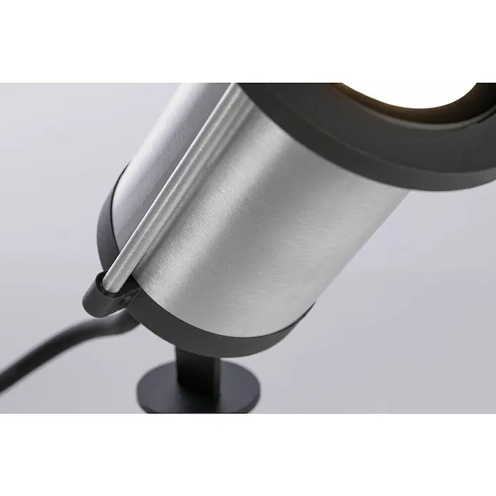Paulmann Plug & Shine LED-Gartenstrahler Spot - Ø x H: 8,8 x 26,5 cm, Anthrazit, 5,1 W, IP65 - Nahaufnahme einer modernen, silbernen Gartenleuchte mit schwarzem Sockel und hellem Lichtschein. Die Lampe hat ein schlichtes, zylindrisches Design.