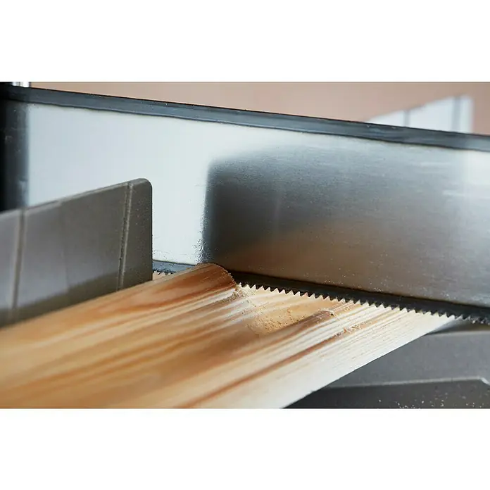 Stanley Gehrungslade 1-20-800 mit Säge - L x B x H: 560 x 143 x 95 mm - Eine Nahaufnahme einer Handsäge, die ein Stück Holz schneidet, wobei der Fokus auf den scharfen Zähnen und der Textur des Holzes liegt.