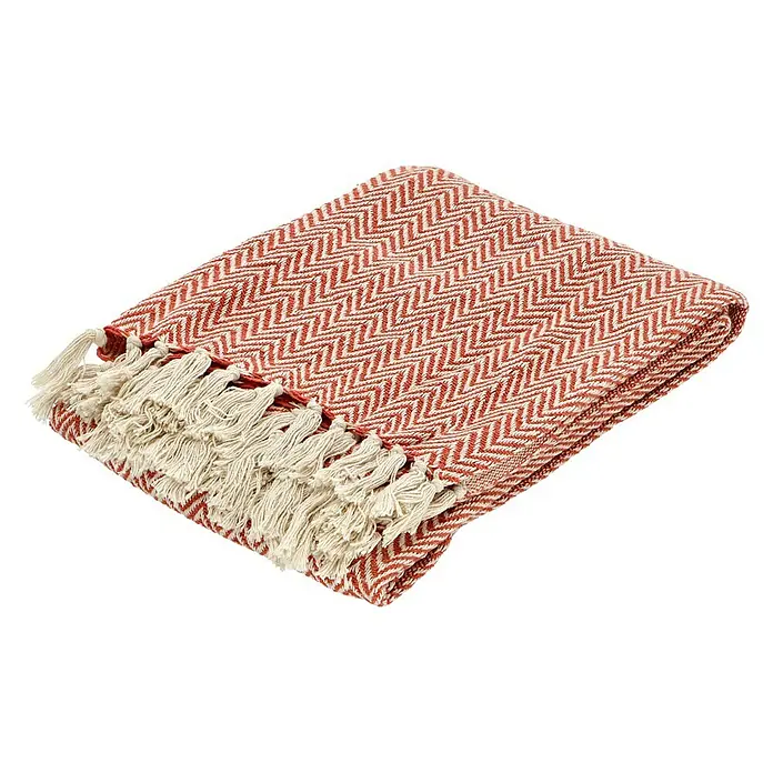 Decke Zigzag - Rostrot, 170 x 130 cm, 100 % Baumwolle - Gefaltete orangefarbene Baumwolldecke mit Fischgrätenmuster und Fransen, ideal für gemütliche Stunden oder als Dekoration.