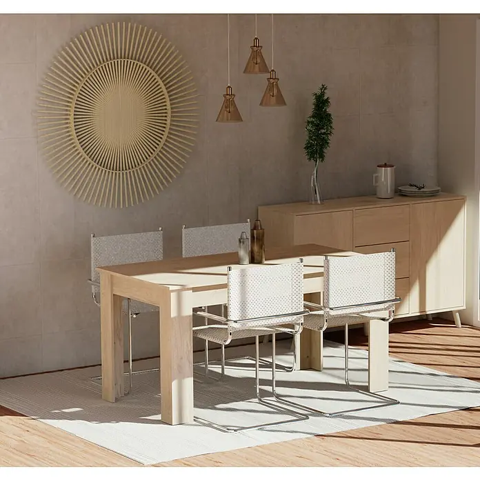 Muebles Pitarch Oslo Aparador - L x An x Al: 40 x 140 x 89 cm, Roble aurora, Número de cajones: 3 ud. - Un comedor luminoso con una mesa de madera, sillas con marco cromado y decoración artística en la pared. Las lámparas colgantes añaden un toque elegante.