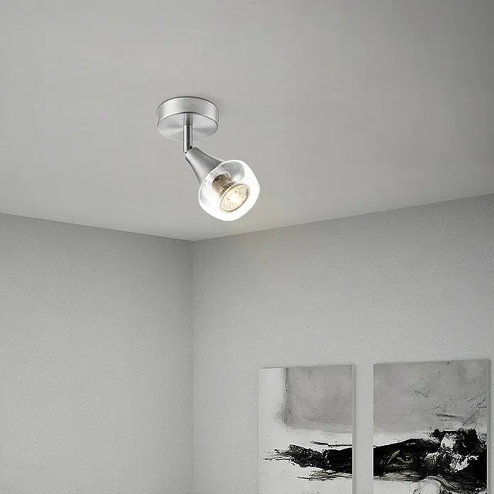 Home Sweet Home LED-Deckenstrahler rund Vaya - 5 W, Ø x H: 9,5 x 16,5 cm, Silber, Warmweiß - Nahaufnahme einer modernen Deckenleuchte mit verstellbarem Spot und klarem Lampenschirm, die ein warmes Licht in den Raum wirft.