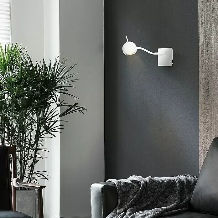 Home Sweet Home LED-Wandstrahler Bollo Flex - 5,8 W, L x B x H: 14 x 14 x 11,5 cm, Sandweiß, Warmweiß - Weiße verstellbare Wandleuchte, an dunkler Wand montiert, beleuchtet einen Raum.