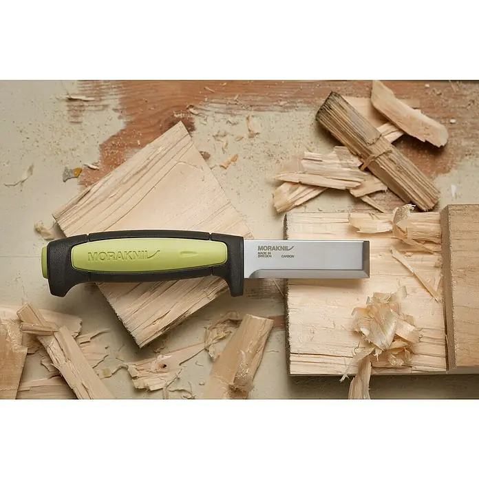 Morakniv Messer Pro Chisel - Klingenlänge: 75 mm, Klingenstärke: 3,1 mm - Nahaufnahme eines MoraKniv-Schnitzmessers mit hellgrünem Griff auf einer Holzoberfläche, umgeben von Holzspänen.