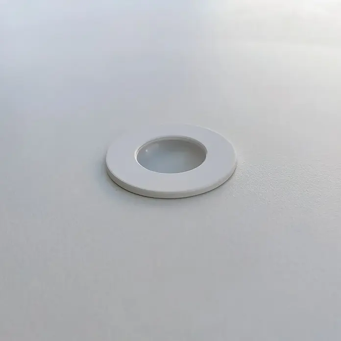 Muebles Pitarch Tibet Armario de puertas correderas - L x An x Al: 55 x 150 x 200 cm, Blanco - Primer plano de un foco LED empotrable, redondo y blanco, colocado en una superficie blanca, que ofrece una solución de iluminación elegante y discreta.