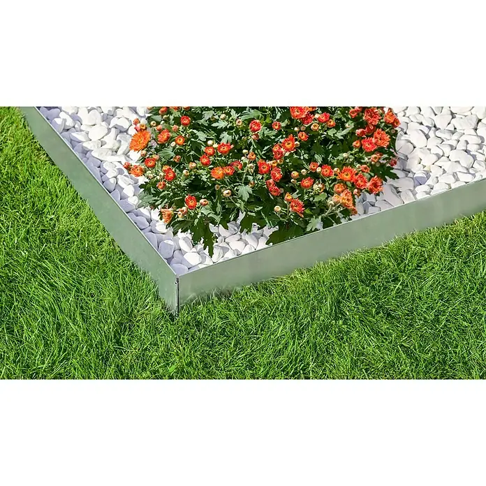 Gardol Rasenkante - 4 Stk., 118 x 13 cm, Grau - Nahaufnahme einer Metall-Gartenumrandung, die ein Blumenbeet mit weißen Steinen und orangefarbenen Blumen von einem grünen Rasen trennt.