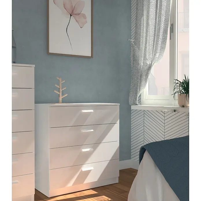 Muebles Pitarch Tibet Cómoda - L x An x Al: 40 x 74 x 78 cm, Blanco, Número de cajones: 4 ud. - Una mesita de noche blanca con tres cajones y un pequeño árbol de joyería en un dormitorio luminoso.