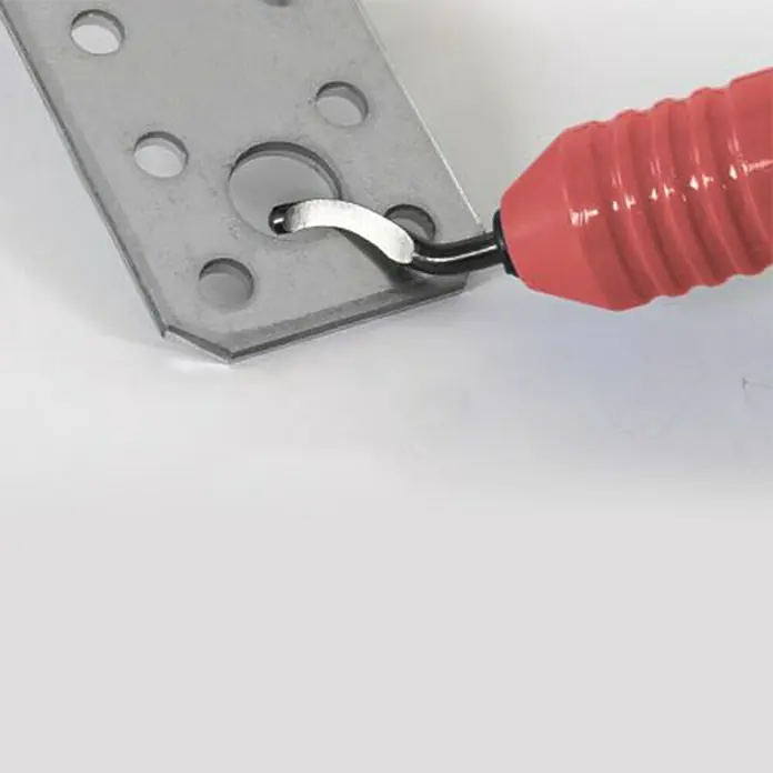 Wisent Desbarbador - 12 pzs., Carcasa giratoria 360° - Primer plano de una herramienta de desbarbado con mango rojo utilizada en una placa de metal con agujeros, eliminando rebabas.