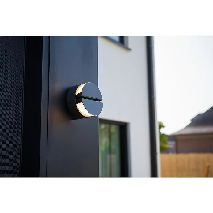 Lutec Aplique exterior LED Eklips - 13 W, 161 x 161 x 146 mm, Gris oscuro, IP54 - Lámpara moderna de exterior en negro, diseño circular con luz blanca cálida, montada en una fachada oscura.