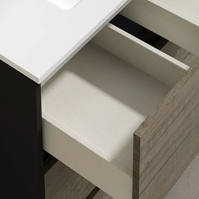 Artysan Conjunto de mueble de baño Africa - Ancho: 60 cm, 3 pzs., Nebraska, Mate - Cajón de un tocador moderno con encimera blanca y acabado de vetas de madera. El cajón está parcialmente abierto, mostrando el interior.