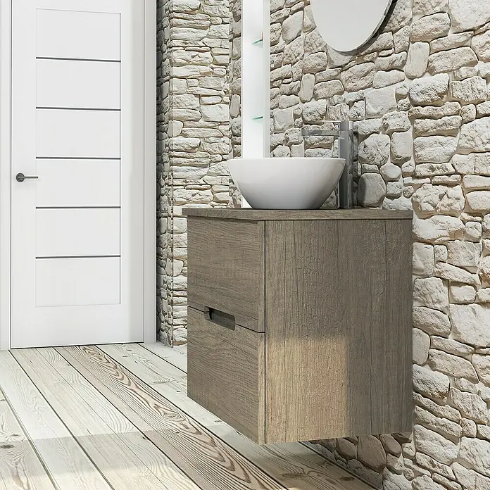Artysan Conjunto de mueble de baño Loop Top - Ancho: 60 cm, 4 pzs., Nebraska, Mate - Lavabo de baño moderno con mueble de madera, sobre un suelo de madera frente a una pared de piedra.