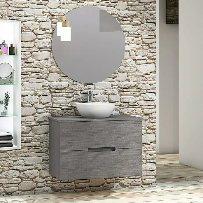 Artysan Conjunto de mueble de baño Loop Top - Ancho: 80 cm, 4 pzs., Ceniza, Mate - Mueble de baño gris con espejo redondo y lavabo sobre encimera frente a una pared de piedra rústica para un ambiente moderno.